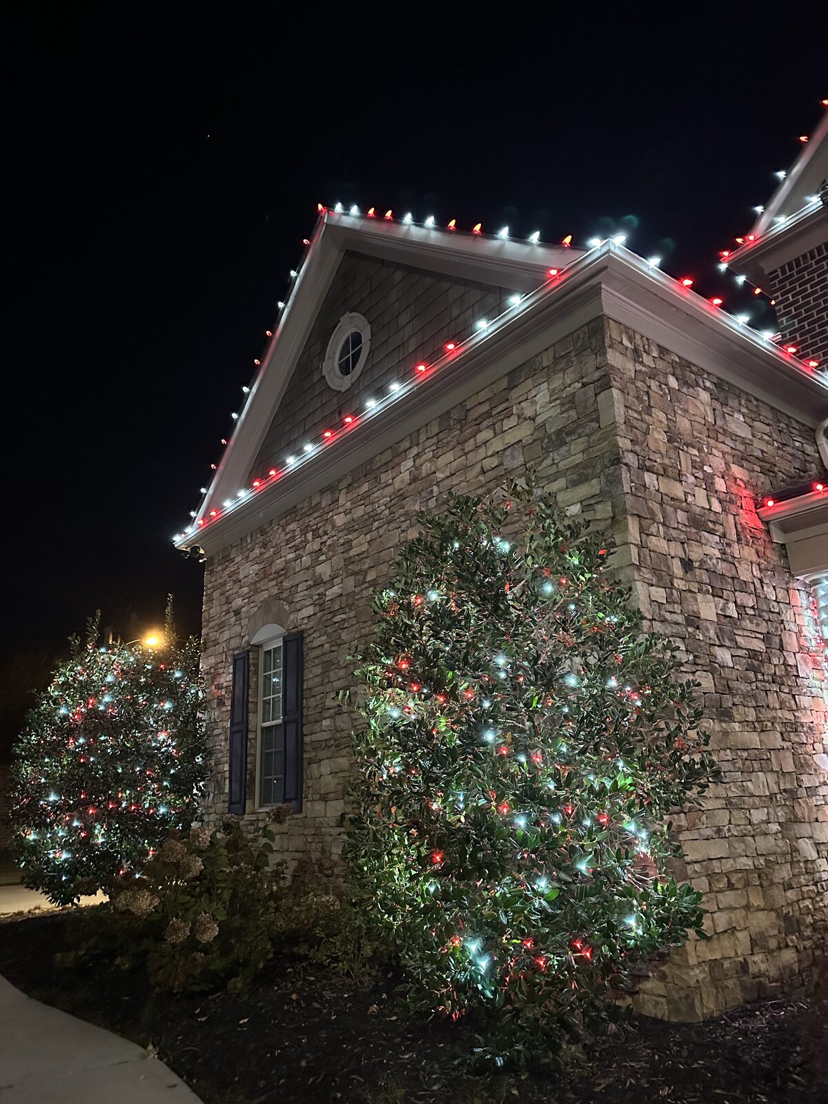 Evening view of a home outlined in Christmas lights