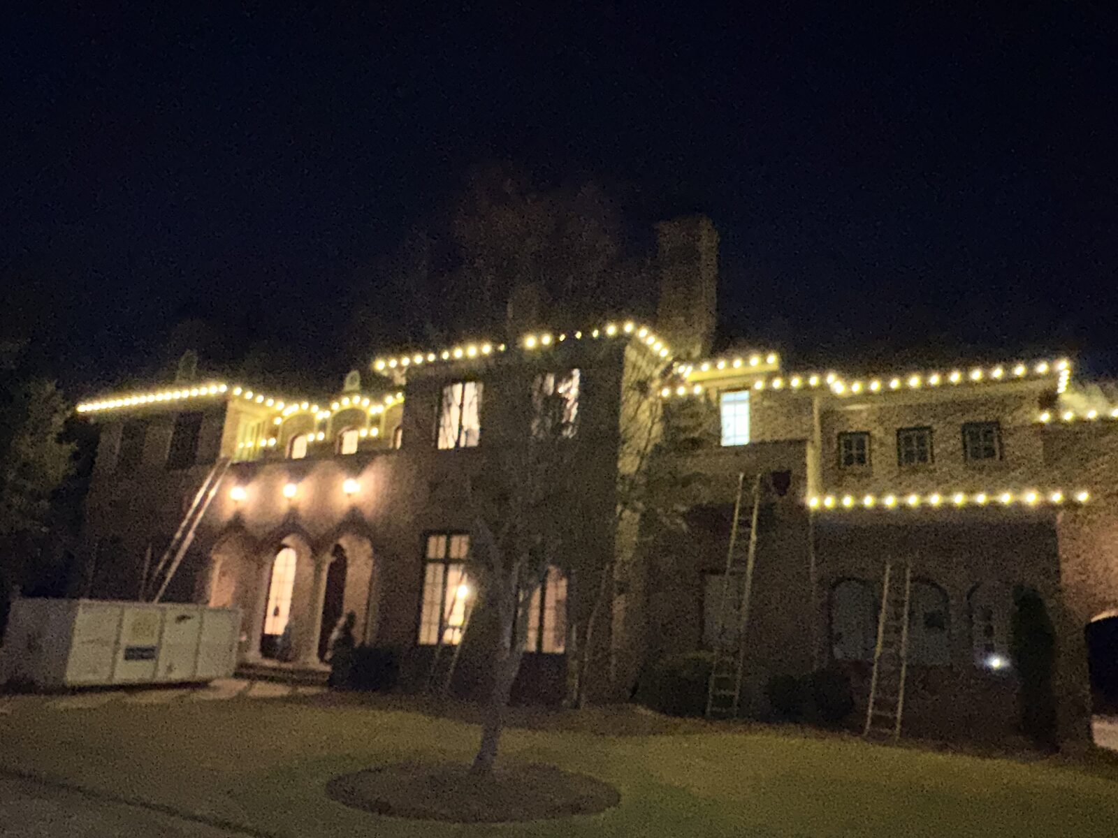 Home glowing with warm white Christmas lights at dusk