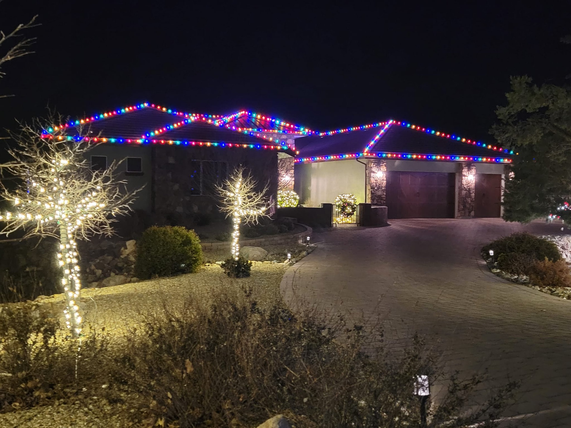 Home roofline outlined in warm white Christmas lights