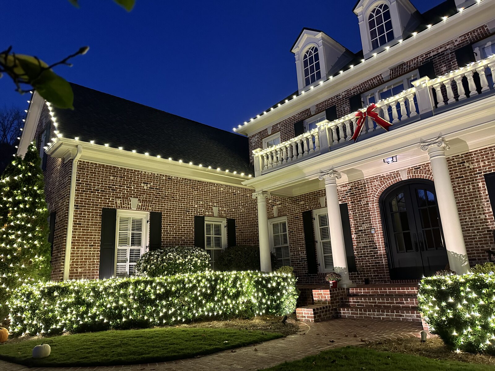 Home with lighted peaks and a lit walkway