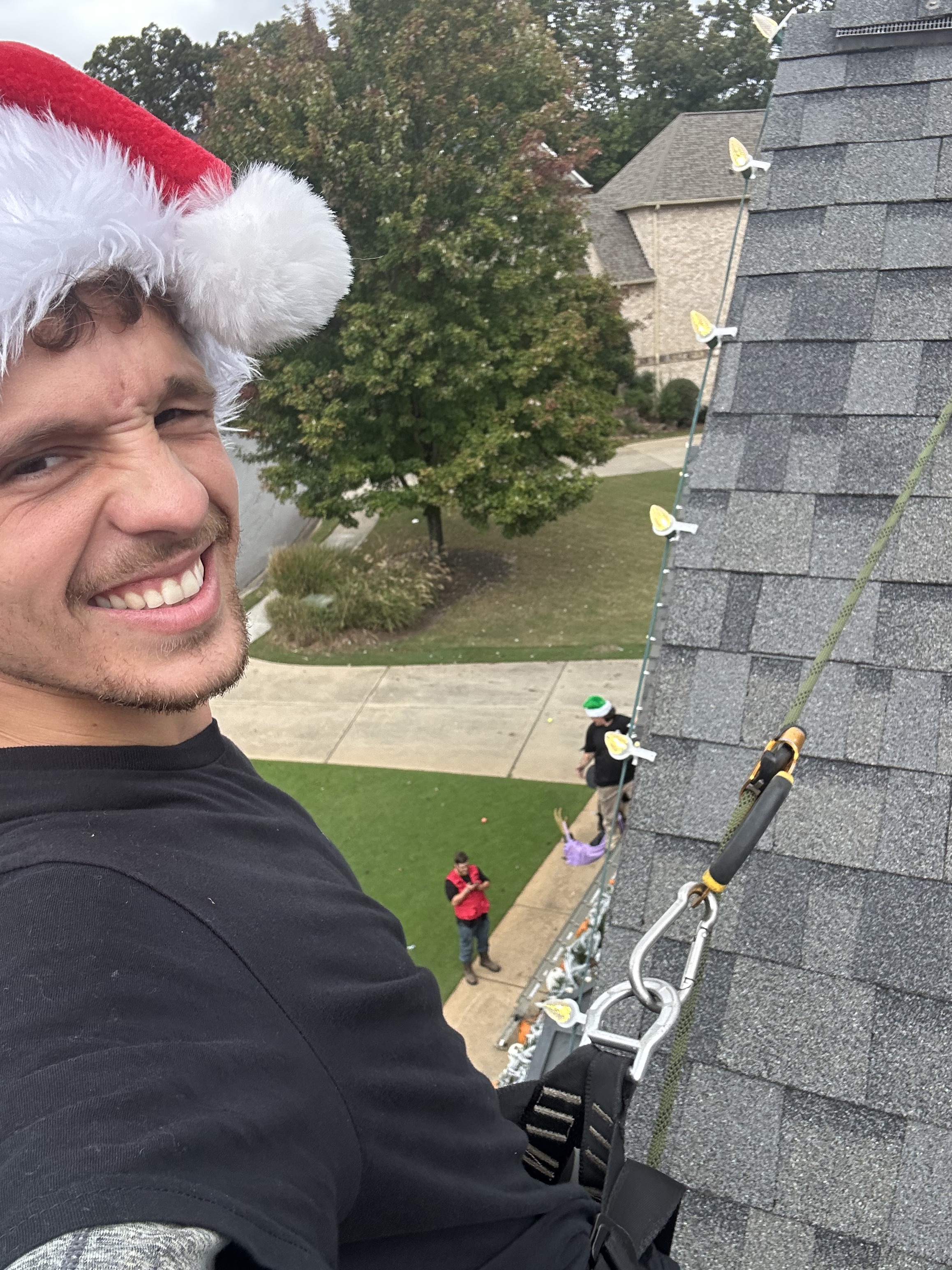 Installer placing light clips along a roof edge