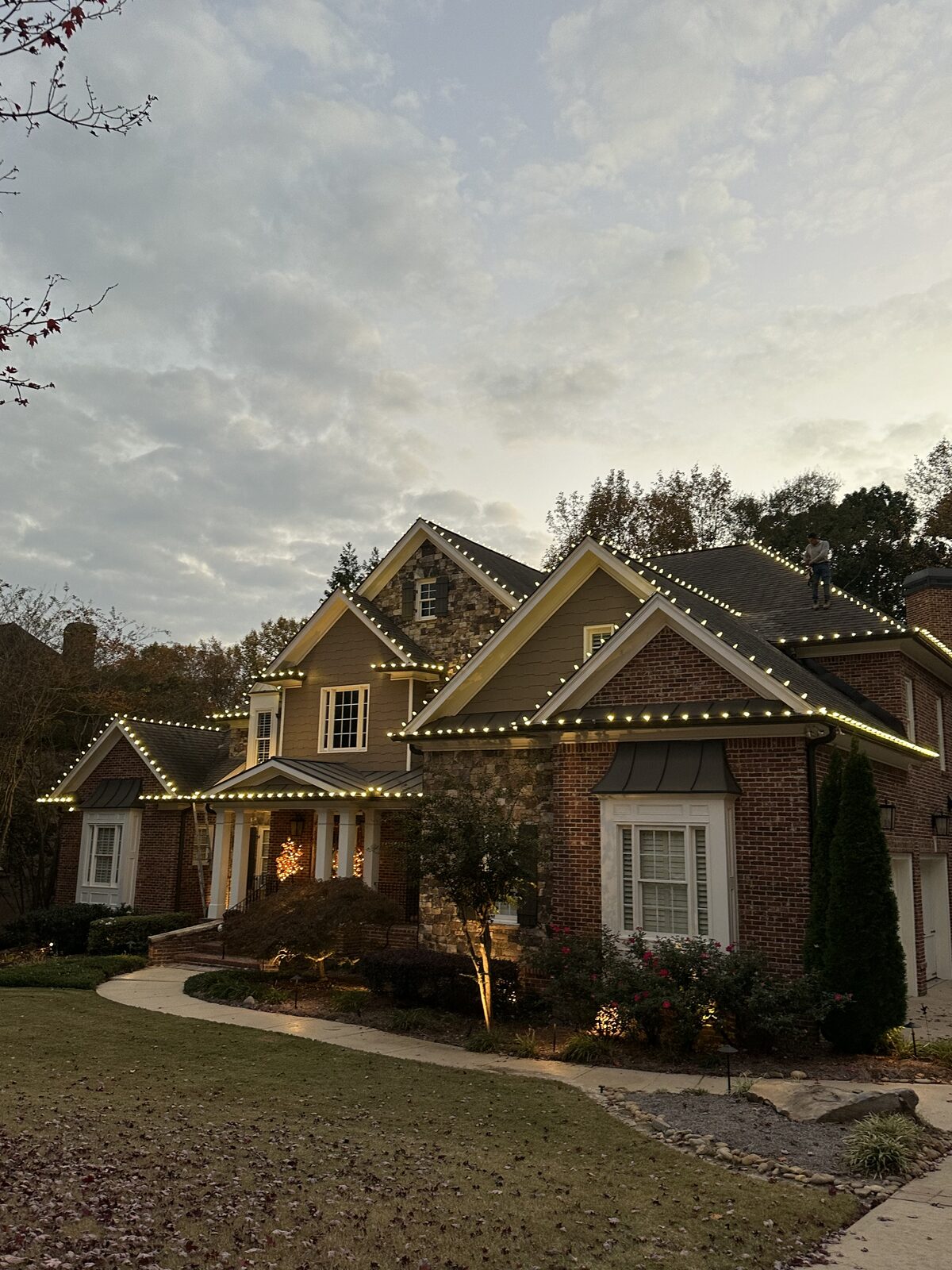 Columns wrapped in lighted garland at a front porch